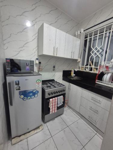a kitchen with a refrigerator and a stove at New Barcelona in Mombasa