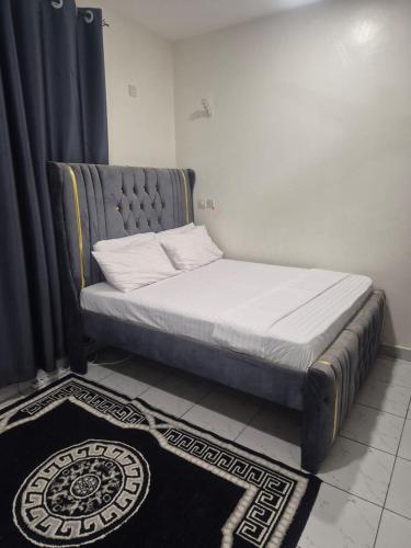a bed in a room next to a black curtain at New Barcelona in Mombasa
