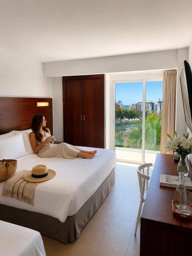 a woman laying on a bed in a hotel room at Hotel Astoria Park in Lloret de Mar