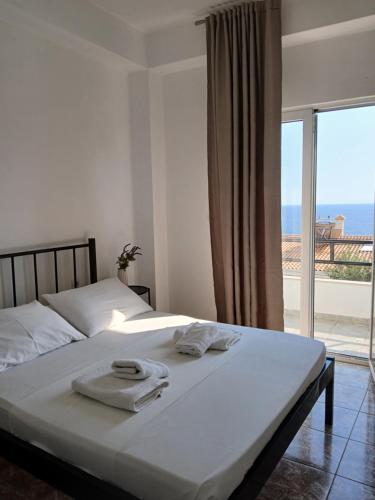 a bedroom with a bed with a view of the ocean at Bel Air Rooms in Himare