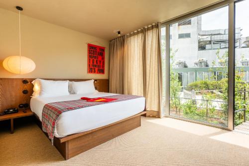 a bedroom with a bed and a large window at chic&basic Tokyo Hoose in Porto