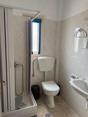 a bathroom with a toilet and a shower and a sink at Orama Hotel in Sígrion
