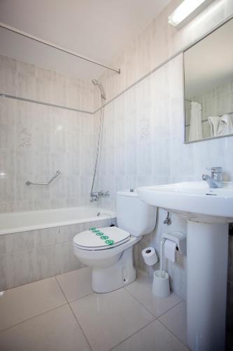 a white bathroom with a toilet and a sink at Hotel Beri - Can Llançà in Llança