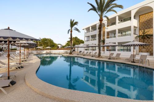 a swimming pool in front of a hotel at Wyndham Mallorca Portocolom Resort in Portocolom