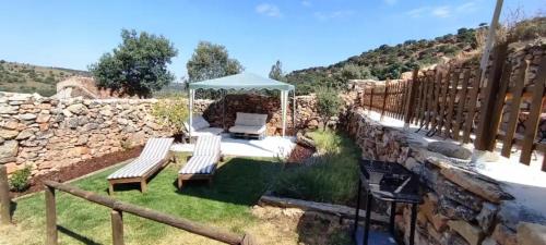 a garden with two benches and a gazebo at Donde Elvira in Valderromán