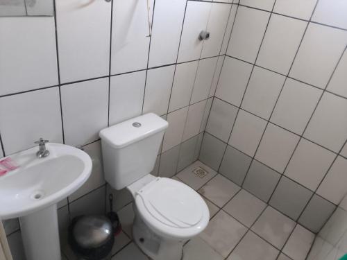 a white bathroom with a toilet and a sink at Recanto do trabalho in Brasília