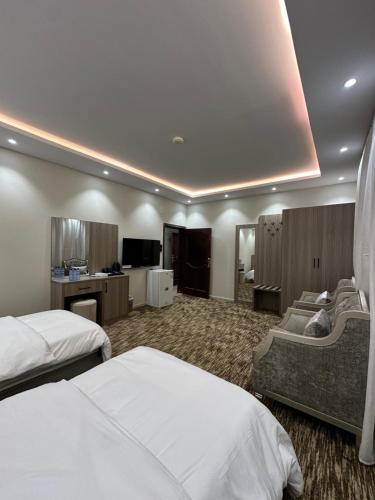 a hotel room with two beds and a television at الملاذ الهادي in Al-ʿUla
