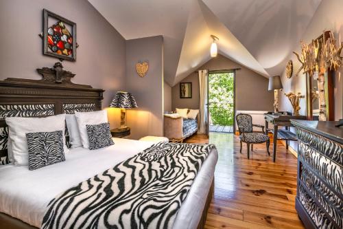 a zebra themed bedroom with a bed and a desk at Hôtel Restaurant L'Arbre à Pain in Altier
