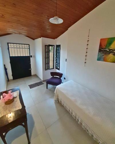 a bedroom with a bed and a chair and a table at Temporario La Marcela in Resistencia