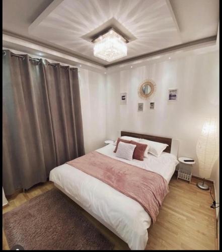 a bedroom with a large bed and a chandelier at Apartman Ika in Belgrade