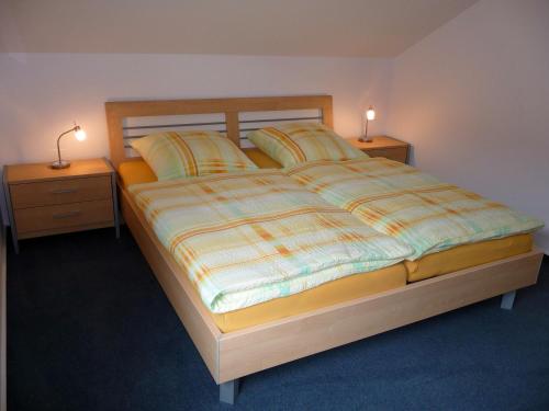 a bedroom with a large bed with two night stands at Backhaus Meeresblick in Meeschendorf