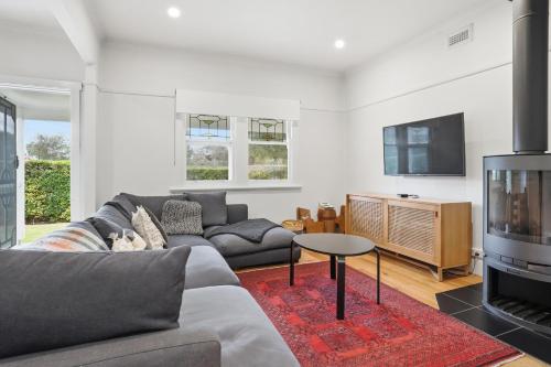 a living room with a couch and a tv at Coastal Cottage Retreat in Barwon Heads