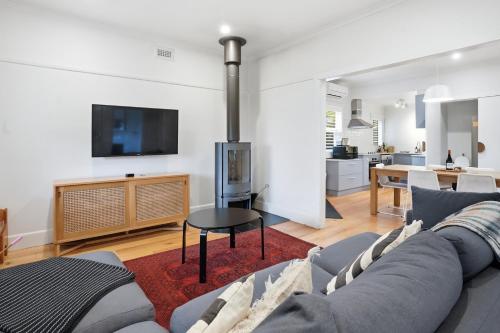a living room with a couch and a table at Coastal Cottage Retreat in Barwon Heads