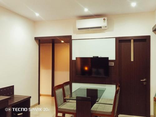 a dining room with a glass table and a microwave at Hotel Mumbai House Thane in Thane