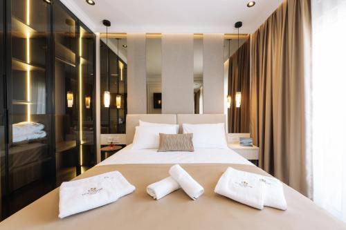 ein Schlafzimmer mit einem großen Bett und zwei weißen Handtüchern in der Unterkunft Hotel Dolcinium in Ulcinj