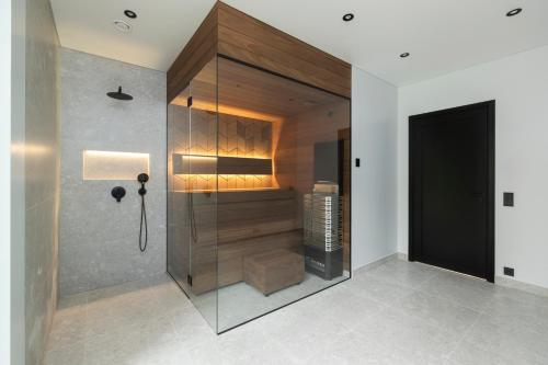 a bathroom with a shower with a glass wall at Jõelähtme Golf Villa with Sauna and Terrace Grill - near EGCC Golf Course in Manniva
