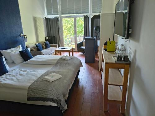 a bedroom with a bed and a living room at Meerhotel Großenbrode in Großenbrode