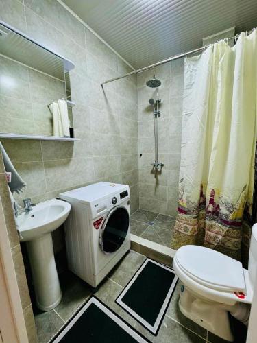 a bathroom with a toilet sink and a washing machine at Квартира in Koshkolʼ