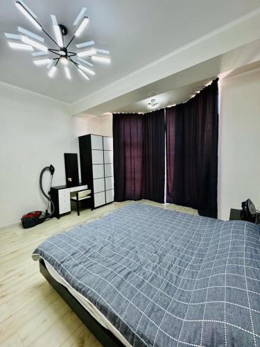 a bedroom with a bed and a ceiling fan at Квартира in Koshkolʼ