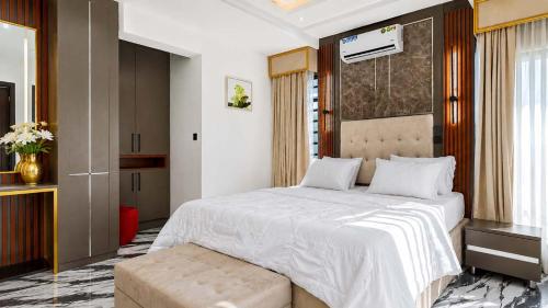 a bedroom with a large white bed and a window at Richgates Apartments in Enugu