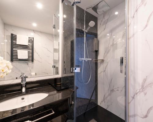 a bathroom with a sink and a shower at PLAZA INN Bruchsal in Bruchsal