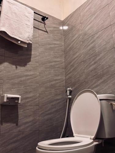 a bathroom with a toilet and a towel on a wall at Makao Home in Arusha