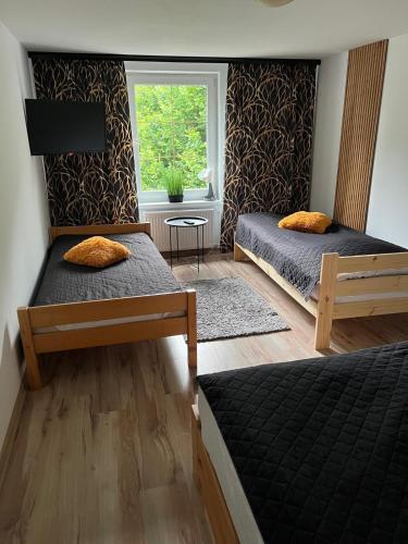 two beds in a room with a window at Agroturystyka Pod Podkową in Darłowo