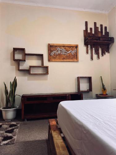 a bedroom with a bed and some pictures on the wall at Makao Home in Arusha