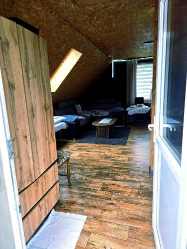 a room with a wooden door and a living room at Apartament Babina Loft in Żarkie Małe