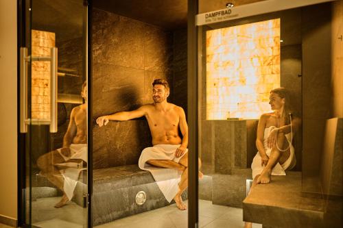 a man sitting in a bath tub with a woman at Vitalhotel Bad Birnbach in Bad Birnbach