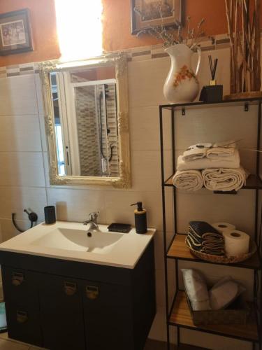 a bathroom with a sink and a mirror and towels at Cascina Rocchino bed and breakfast in Predosa
