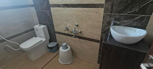 a bathroom with a sink and a toilet at Jazz Inn in Tiruvallūr