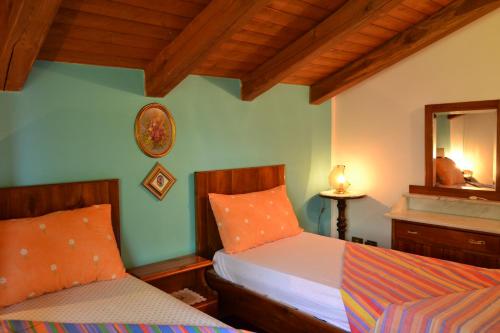 a bedroom with two beds and a mirror at Casa vacanze Ivan Trinko in Savogna