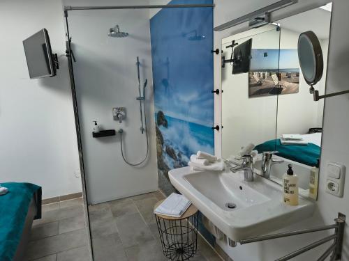 a bathroom with a sink and a shower at Meerhotel Großenbrode in Großenbrode
