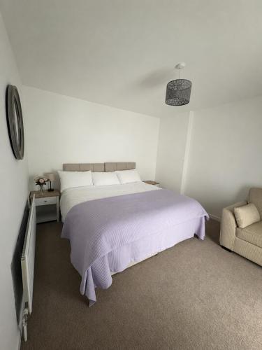 a white bedroom with a bed and a couch at Castleroddy House - spacious country house - king beds - extensive parking in Lislap