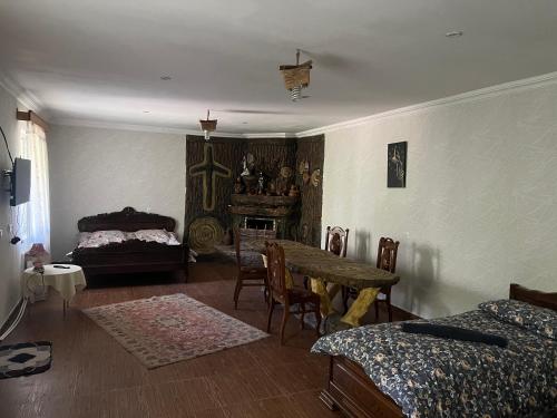 a room with a table and a bed and a table and chairs at Weekend House in Borjomi