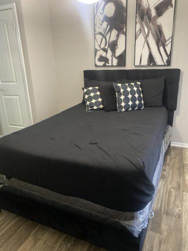 a black bed with two pillows on top of it at Cute 1bdr that sleep 4 minutes from ATT Stadium in Arlington