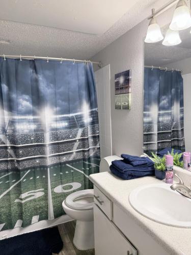 a bathroom with a baseball field shower curtain at Cute 1bdr that sleep 4 minutes from ATT Stadium in Arlington