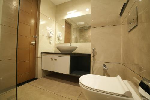 a bathroom with a white toilet and a sink at Mihas Hotels and Resorts in Malappuram