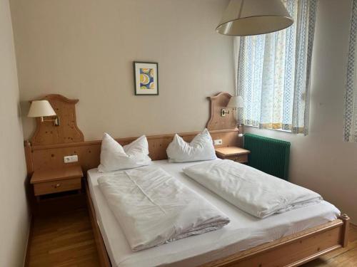 a bedroom with a bed with white sheets and pillows at Breitenfelderhof in Breitenfeld an der Rittschein