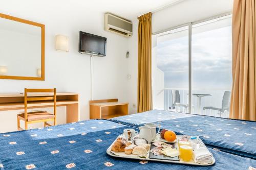 
a breakfast on a bed in a hotel room at Gran Sol Hotel in San Pol de Mar

