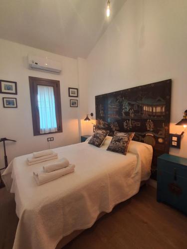 a bedroom with a large white bed with two pillows at Jardines del Acebron in El Rocío