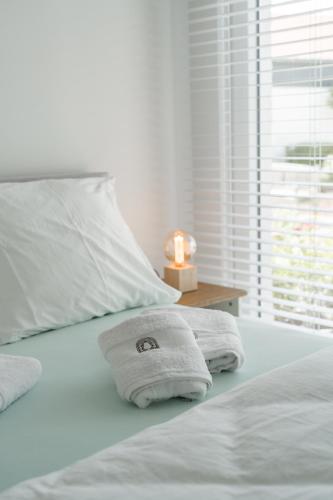 a bed with two towels and a candle on it at Oud Peer in Peer