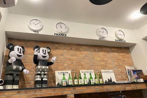 a display of clocks on a wall with bottles of wine at 101 SEOUL HOSTEL (101 โซล โฮสเทล) in Bangkok