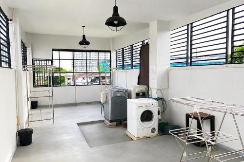 a room with a washing machine and some windows at 101 SEOUL HOSTEL (101 โซล โฮสเทล) in Bangkok