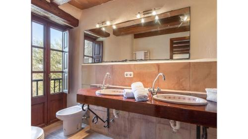 a bathroom with two sinks and a mirror at Finca Son Xona in Capdepera