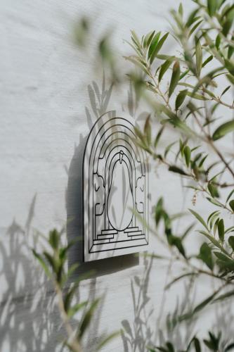 a metal lightswitch on a wall next to a plant at Oud Peer in Peer