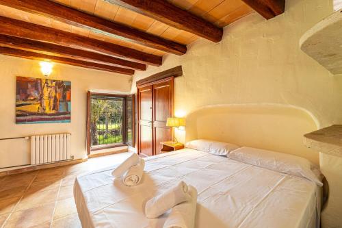 a large white bed in a room with a window at Finca Son Xona in Capdepera