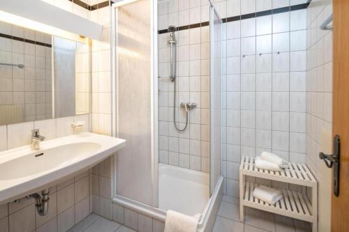 a white bathroom with a shower and a sink at Breitenfelderhof in Breitenfeld an der Rittschein