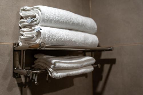 a towel rack with towels in a bathroom at Mangal Hotel in Olgina